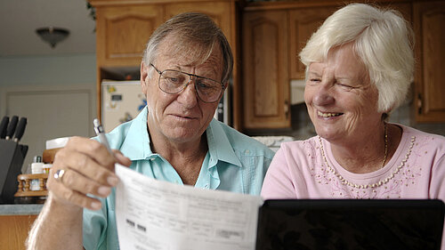 An elderly couple sorting out their bills.