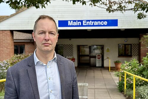 Richard Foord standing in front of the entrance to Seaton Hospital