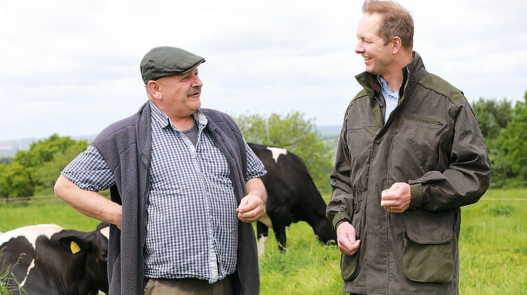 Foord and Farmer Cow field Richard Foord walking and talking with a farmer in a cow field