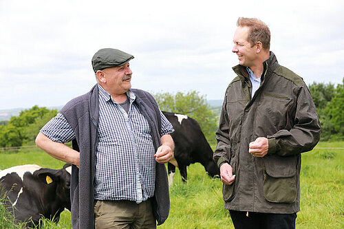 Foord and Farmer Cow field Richard Foord walking and talking with a farmer in a cow field