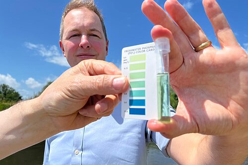 Richard Foord MP holding a water acidity tester