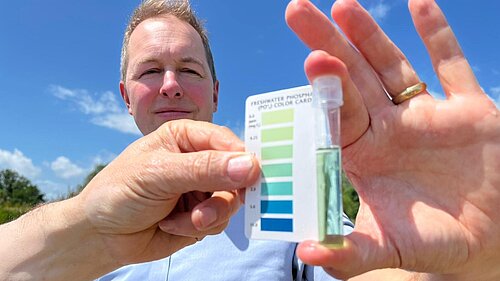 Water tester Richard Foord holding a water quality tester