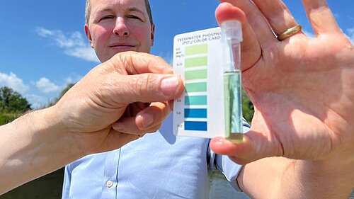 Water tester Richard Foord holding a water quality tester