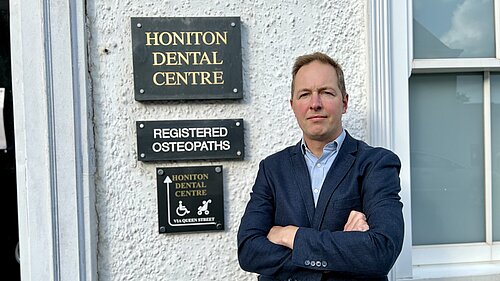 Richard Foord standing in frnt of the sign for Honiton Dental Centre