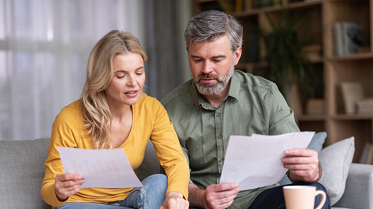Middle aged husband and wife calculating their budget together.