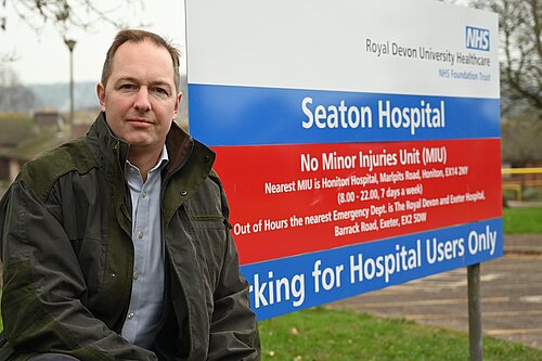 Richard Foord next to the sign for Seaton Hospital