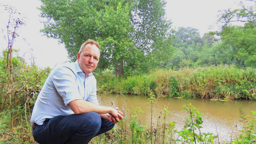 A photo of Richard Foord crouched down by the river Otter