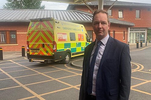 Richard Foord standing in front of an ambulance