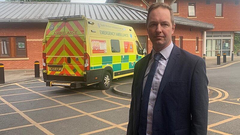 Richard Foord standing in front of an ambulance