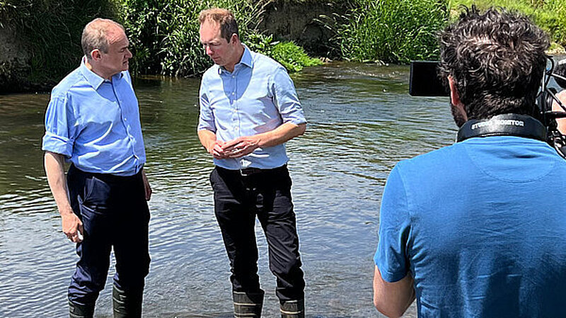 Richard Foord MP and Ed Davey MP standing in a river