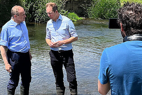 Richard Foord MP and Ed Davey MP standing in a river