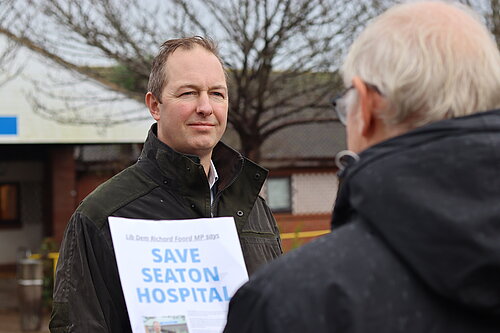 Richard Foord discussing the Save Seaton Hospital petition with a man outside the hospital