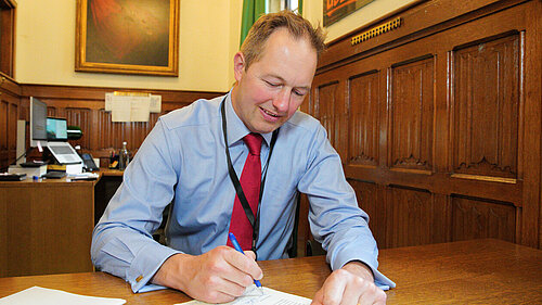 Richard Foord signing a letter