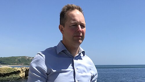 Richard Foord stood by the sea